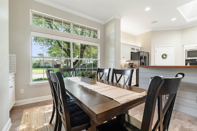 4282 Walden Way, Gulf Breeze, FL 32563 - dining room with ornamental molding, light wood-style floors, baseboards, a towering ceiling, and a skylight