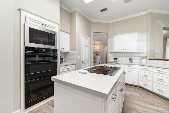 4282 Walden Way, Gulf Breeze, FL 32563 - kitchen with black electric stovetop, built in microwave, light wood-style flooring, ornamental molding, and decorative backsplash