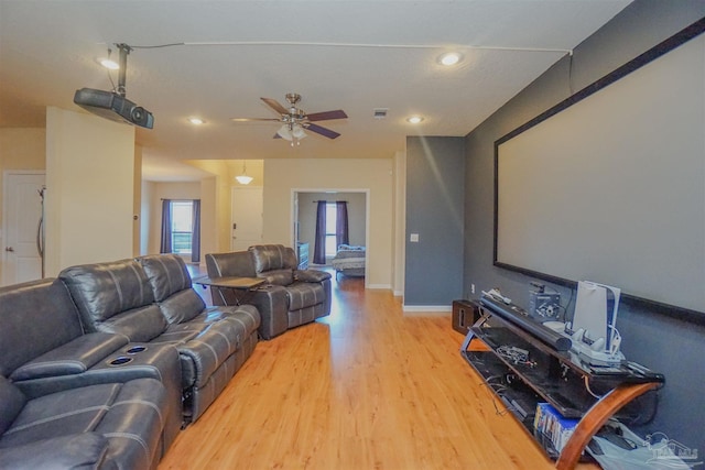 cinema featuring light hardwood / wood-style floors and ceiling fan