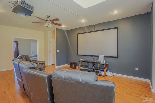 cinema featuring ceiling fan and hardwood / wood-style flooring