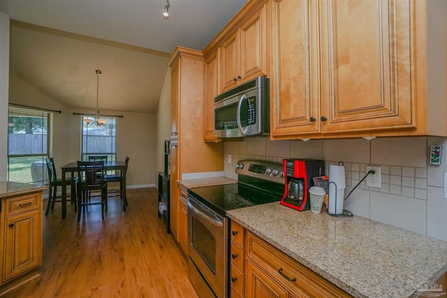 kitchen with light hardwood / wood-style floors, tasteful backsplash, vaulted ceiling, stainless steel appliances, and light stone countertops