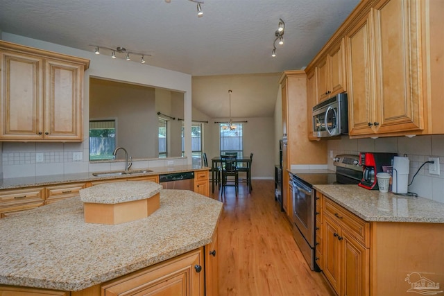 kitchen with vaulted ceiling, stainless steel appliances, sink, and tasteful backsplash