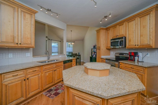 kitchen with stainless steel appliances, a kitchen island, tasteful backsplash, and sink