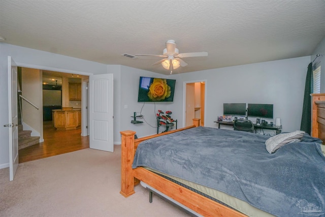 carpeted bedroom featuring a textured ceiling and ceiling fan