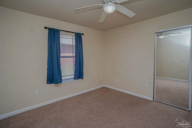 unfurnished room featuring ceiling fan and carpet floors