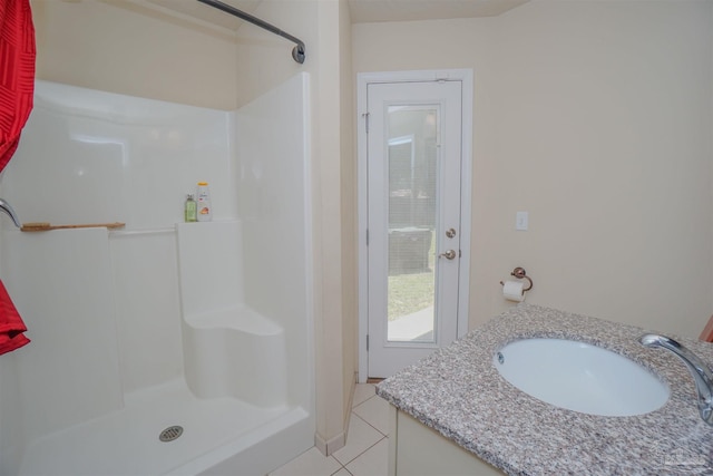 bathroom featuring walk in shower, vanity, and tile patterned floors