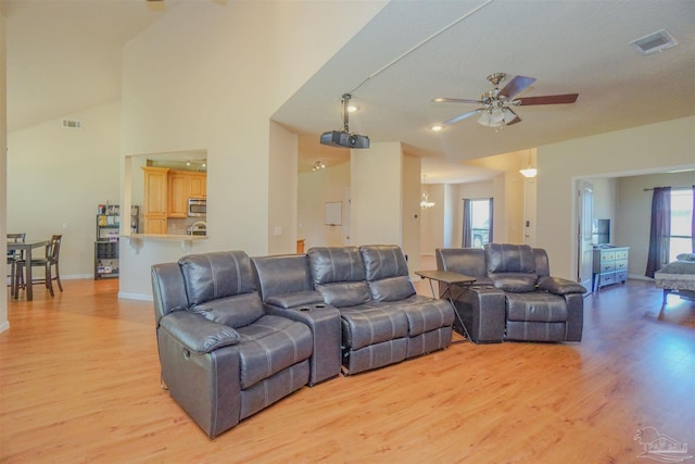 living room with ceiling fan, light wood-type flooring, and high vaulted ceiling