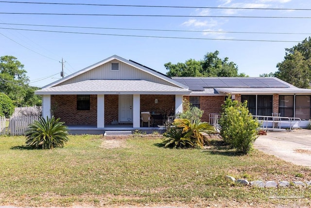 view of front of home featuring a front lawn and solar panels