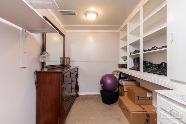 walk in closet featuring light colored carpet