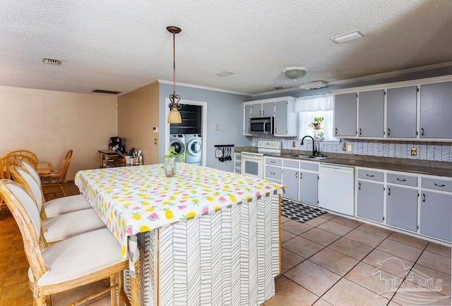 kitchen featuring crown molding, white appliances, independent washer and dryer, decorative backsplash, and sink