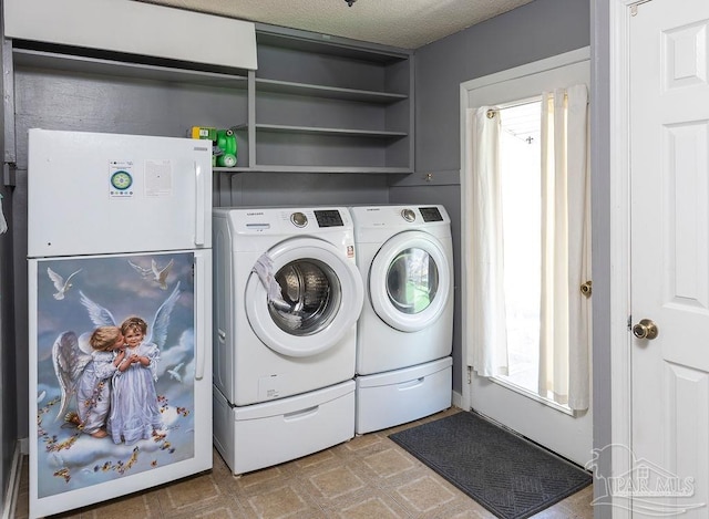 washroom with separate washer and dryer and a textured ceiling