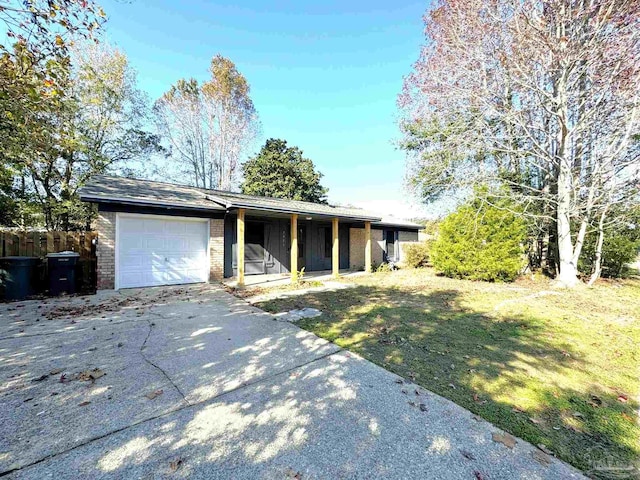 ranch-style home featuring a garage and a front lawn