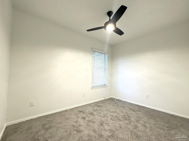 empty room featuring dark colored carpet, a textured ceiling, and ceiling fan