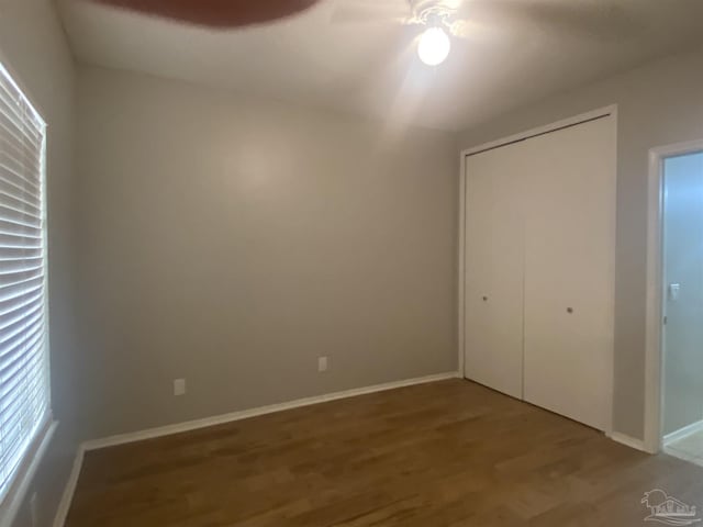 unfurnished bedroom featuring ceiling fan, wood-type flooring, and a closet