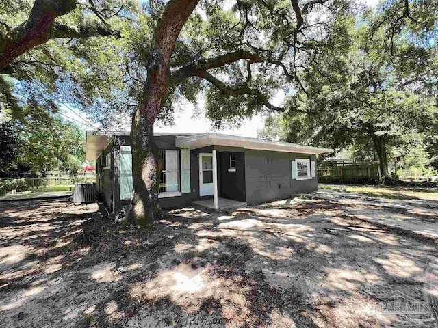 view of front of house featuring fence and central AC unit