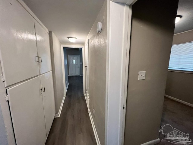 hall featuring dark wood-style floors and baseboards