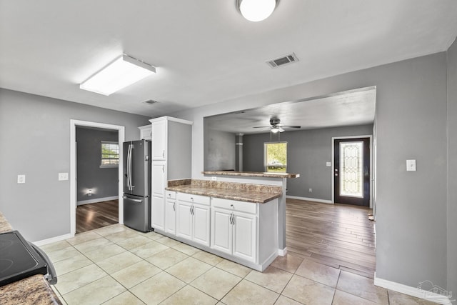 333 Western Pine Rd, Cantonment, FL 32533 - kitchen with white cabinets, visible vents, freestanding refrigerator, baseboards, and a peninsula