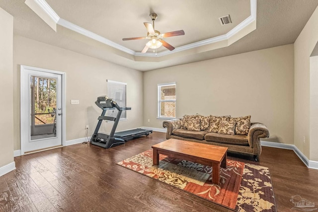 interior space featuring crown molding, ceiling fan, a tray ceiling, and dark hardwood / wood-style flooring