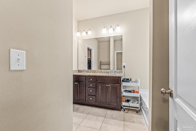 bathroom featuring tile patterned floors, a bath, and vanity