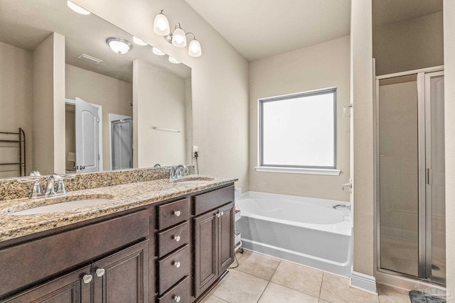 bathroom with tile patterned flooring, vanity, and shower with separate bathtub