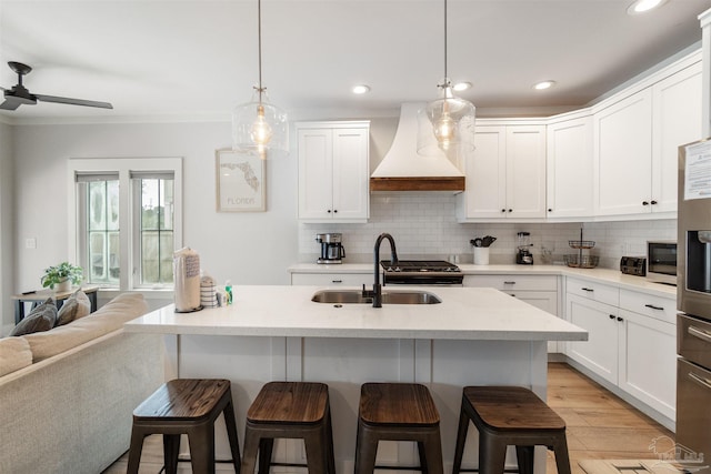 2550 N 11th Ave, Pensacola, FL 32503 - kitchen featuring custom range hood, a sink, a kitchen breakfast bar, stainless steel appliances, and backsplash