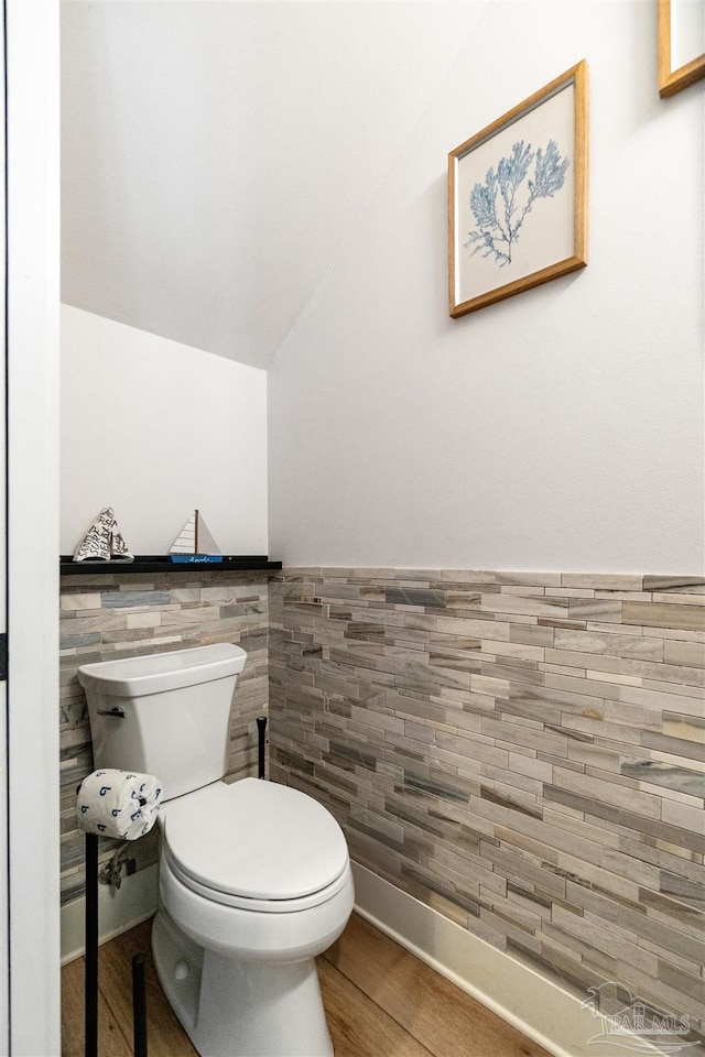 2550 N 11th Ave, Pensacola, FL 32503 - bathroom featuring toilet, vaulted ceiling, wood finished floors, tile walls, and a wainscoted wall