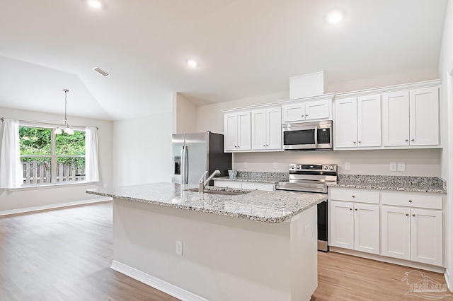 7929 Huntington Creek Ln, Pensacola, FL 32526 - kitchen featuring appliances with stainless steel finishes, a sink, white cabinetry, light wood-style floors, and vaulted ceiling