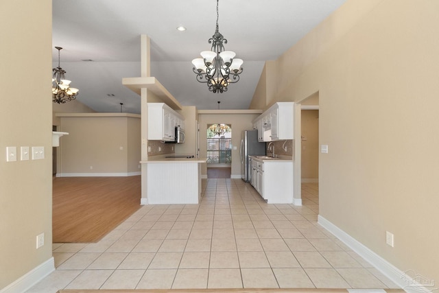 kitchen with white cabinetry, light tile patterned floors, pendant lighting, and a chandelier