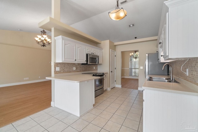 kitchen with stainless steel appliances, sink, hanging light fixtures, and white cabinets