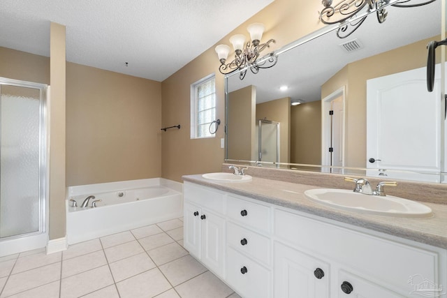 bathroom with tile patterned flooring, vanity, shower with separate bathtub, and a textured ceiling