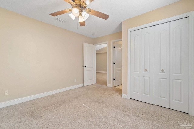 unfurnished bedroom featuring light colored carpet, ceiling fan, and a closet