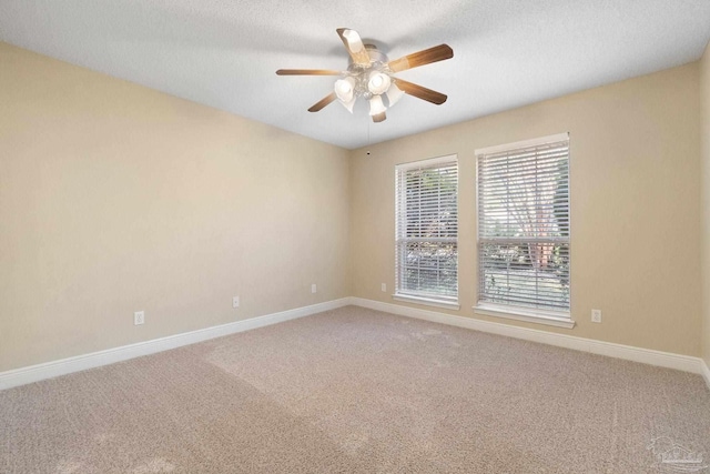 carpeted spare room featuring a textured ceiling and ceiling fan