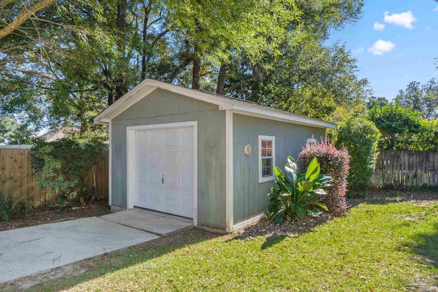 view of outdoor structure with a garage and a lawn