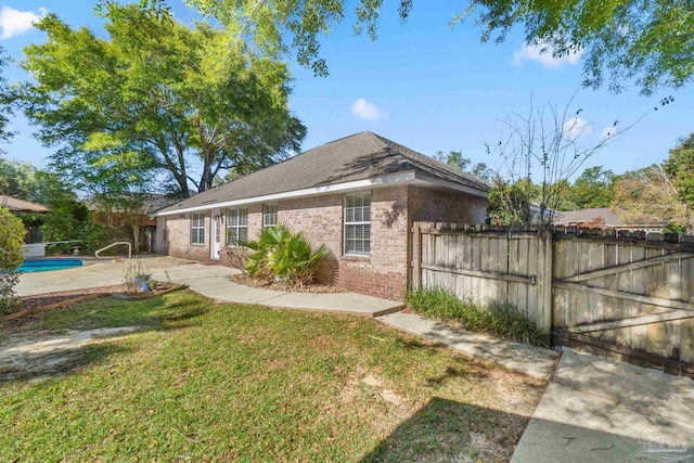 back of house with a yard, a fenced in pool, and a patio