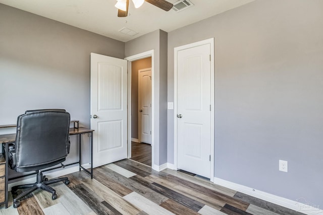 home office with dark hardwood / wood-style floors and ceiling fan