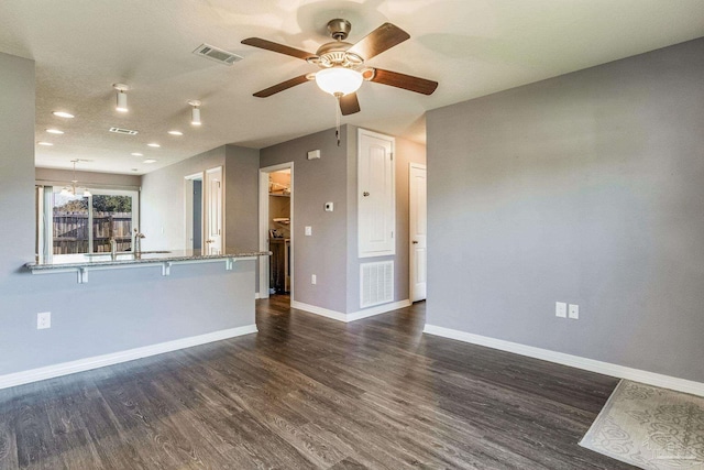 unfurnished living room with dark hardwood / wood-style flooring, ceiling fan, and sink