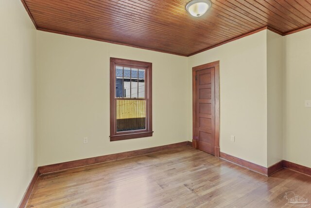 spare room featuring light hardwood / wood-style flooring, crown molding, and wood ceiling