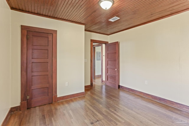 spare room with wood-type flooring, wooden ceiling, and crown molding