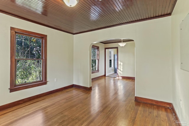 spare room with wood-type flooring, ornamental molding, and wood ceiling