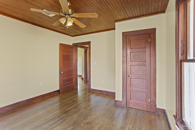 empty room with dark hardwood / wood-style flooring, ceiling fan, crown molding, and wood ceiling