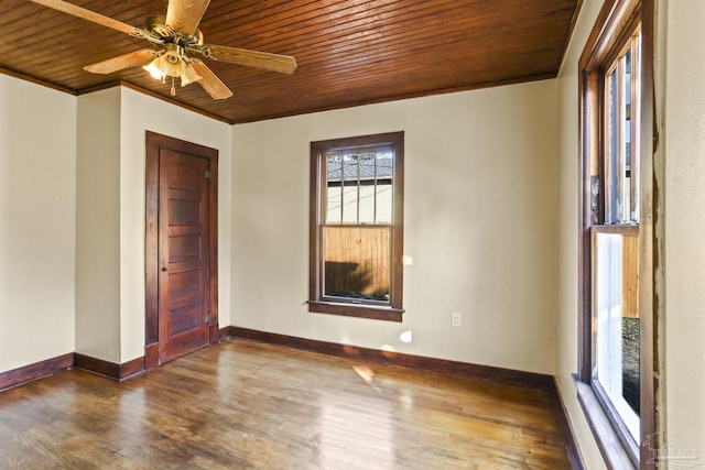 empty room featuring ceiling fan, crown molding, wood ceiling, and dark wood-type flooring