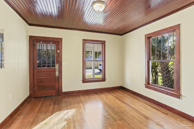 entryway with hardwood / wood-style floors, wooden ceiling, crown molding, and a wealth of natural light