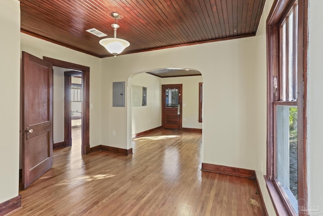 unfurnished room featuring light wood-type flooring, electric panel, crown molding, and wood ceiling