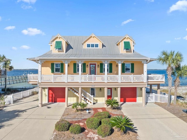 view of front facade featuring a water view, covered porch, and a garage