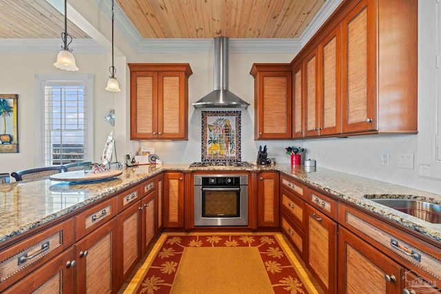 kitchen featuring wall chimney range hood, light stone counters, decorative light fixtures, wood ceiling, and appliances with stainless steel finishes