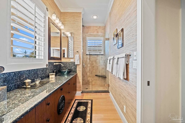 bathroom featuring a wealth of natural light, crown molding, vanity, and a shower with door