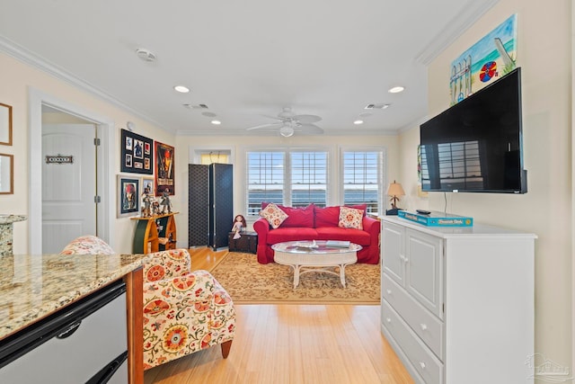 living room with light hardwood / wood-style floors, ceiling fan, and ornamental molding