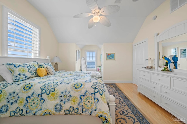 bedroom with ceiling fan, light hardwood / wood-style flooring, and vaulted ceiling