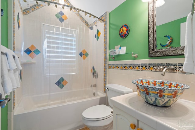 full bathroom with shower / bathtub combination, vanity, tile walls, and toilet