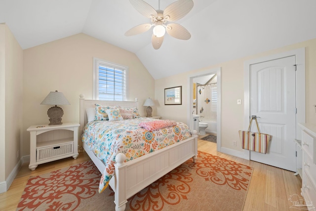 bedroom featuring ceiling fan, ensuite bathroom, lofted ceiling, and light wood-type flooring